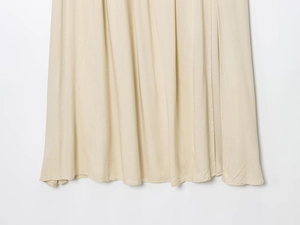 Detailed view of the beige midi dress hem showing premium lightweight fabric texture