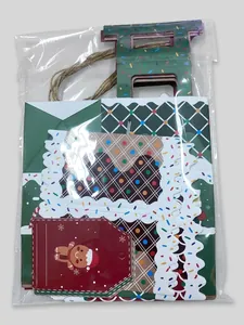 Christmas gift set with green paper bag, decorative cards, and gingerbread man tags