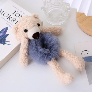 Detailed view of a cute beige plush bear head design on a purple faux fur elastic hair tie