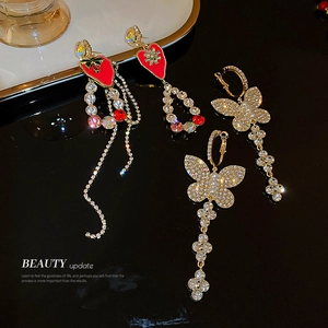 Sparkling rhinestone butterfly and red strawberry tassel earrings in elegant gold finish