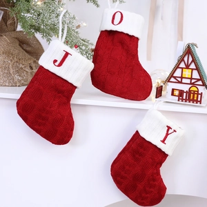 Classic red knitted Christmas stockings with white J O Y letters and festive hanging loops