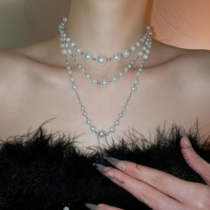 Macro detail of French vintage multi-layer white pearl necklace with metallic silver chain