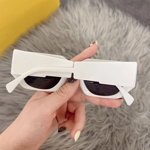 Detail of white rectangle thick frame sunglasses with dark lenses and wide temples