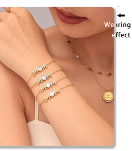 Wearing effect of golden MAM letter bracelet with heart zircon charm on a female wrist