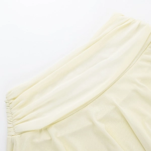 Detailed close-up of light yellow breathable fabric texture and precise pleated design