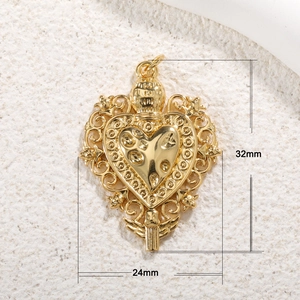 Detailed view of a gold-plated heart pendant with dimensions 32mm by 24mm on beige cloth