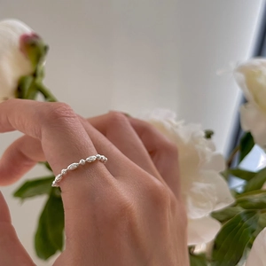 Detail of adjustable 925 silver plated bead chain ring with minimalist irregular texture