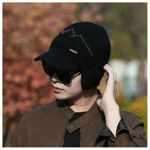 Detail view of winter knitted hat featuring gray mountain pattern and soft ear flaps