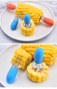 Detail view of colorful corn on the cob holders with stainless steel pins on a plate