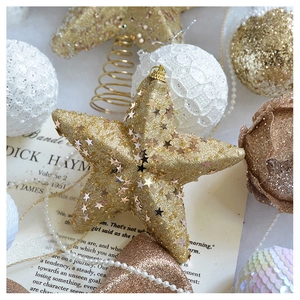 Close-up of champagne gold glitter stars and lace decorative balls on vintage paper