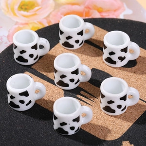 Macro shot of miniature cow print mugs for DIY jewelry making and craft accessories