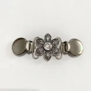 Vue détaillée du clip de châle fleur argentée avec cristal et attaches métalliques