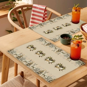 Detailed close-up of Christmas placemats with reindeer patterns on a wooden table setup