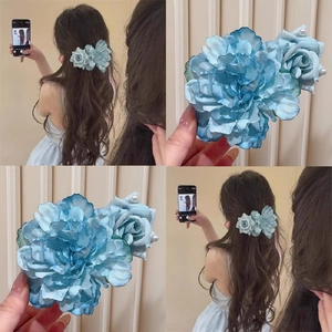 Détail de la pince à cheveux fleur en tissu bleu avec perles et pétales en dégradé