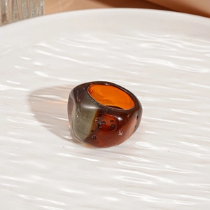Detail of chunky amber and smoke grey resin ring with polished gradient finish
