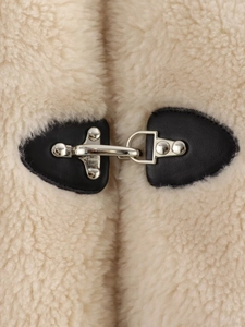 Vue macro détaillée de la boucle à ressort sur une veste polaire beige avec base en cuir