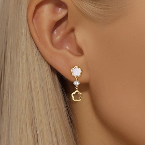 Détail de boucles d'oreilles fleurs en argent S925 doré avec pétales blancs et zircon