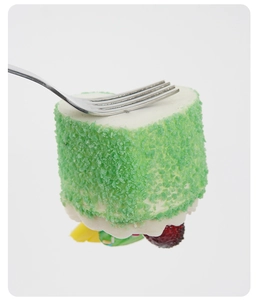Detail of heart-shaped mousse cake fridge magnet with crushed peanuts and fruit garnish