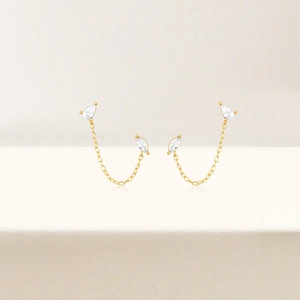 Macro shot of gold tassel drop earrings with sparkling marquise and pear-cut cubic zirconia