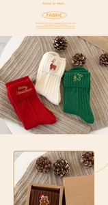 Detailed view of Christmas cotton socks with reindeer and tree embroidery in gift box
