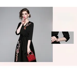 Dettaglio del ricamo floreale colorato e dello scollo a V su questo elegante abito nero a trapezio