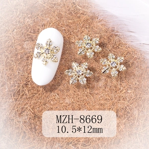Macro detail of 10.5x12mm gold snowflake nail charm with sparkling rhinestones for DIY art