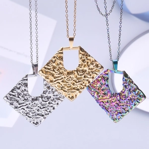 Three textured geometric rhombus necklaces in silver, gold, and rainbow finishes