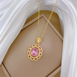 Gros plan d'un pendentif ovale rose avec diamants sur une chaîne en or élégante