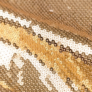 Detaillierte Nahaufnahme goldener Pailletten auf einem schimmernden Abendkleid-Stoff