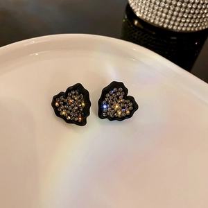 Macro de boucles d'oreilles cœur noir avec cristaux et bords à texture lave