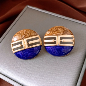 Detail of vintage round enamel stud earrings with brown and blue marble pattern