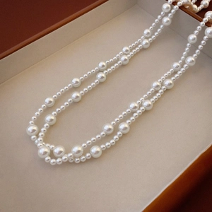 Detail of elegant double-layered white pearl necklace showing glossy beads and textures