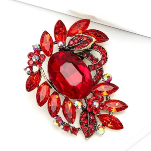 Elegant floral bronze brooch featuring a large red gemstone and colorful rhinestones