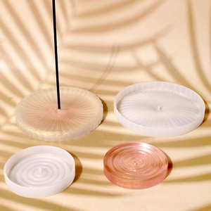 Macro view of textured circular silicone molds and resin incense holder crafts with shadows