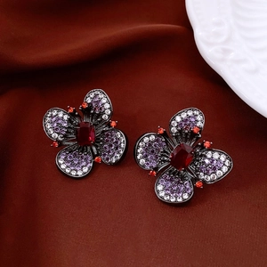 Vue détaillée de boucles d'oreilles papillon vintage avec cristaux rouges et zircons