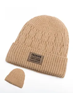 Detailed front and back view of khaki knit beanie with warm fleece lining and leather tag
