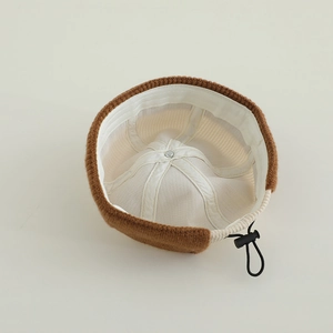 Detail view of knitted beanie with contrast lining and adjustable interior drawstring