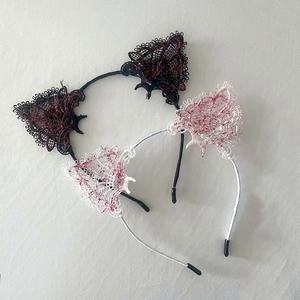 Black and white lace cat ear headbands with red blood splatter design on a gray surface