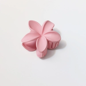 Detail of large 8cm matte pink plumeria flower hair claw clip with frosted texture