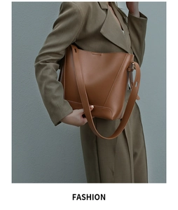 Brown leather bucket bag with wide shoulder strap styled with a professional khaki suit