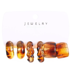 Detailed view of 3-piece amber resin hoop earring set with smooth and twisted textures
