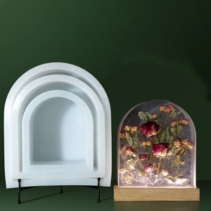 Nesting arched silicone resin molds for DIY crafts with three size variants on green background