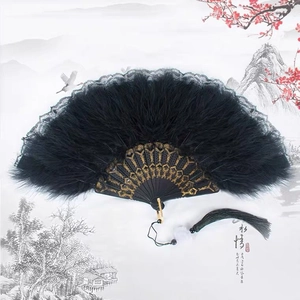 Détail de l'éventail en plumes noires avec gravures dorées et bordures en dentelle