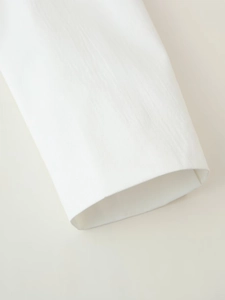Close-up of white blazer jacket sleeve cuff showing premium twill fabric texture