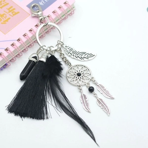 Detail of bohemian dream catcher keychain with black tassels and silver feathers