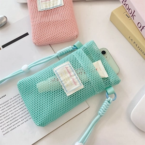 Mesh crossbody phone bag detail with thick woven lanyard and mint green pouch