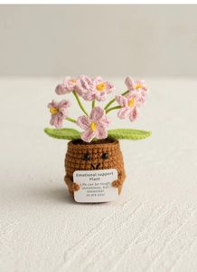 Crochet pink flower pot plant with emotional support card on a textured surface