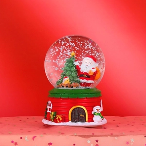 Detailed view of Christmas crystal ball with Santa Claus and red house resin base