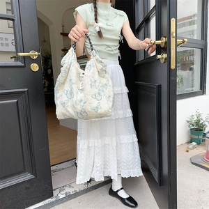Detail of canvas bag with blue butterfly print and woven black and white rope handles