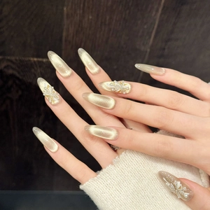 Champagne cat eye press-on nails with 3D white floral carvings and pearl accents